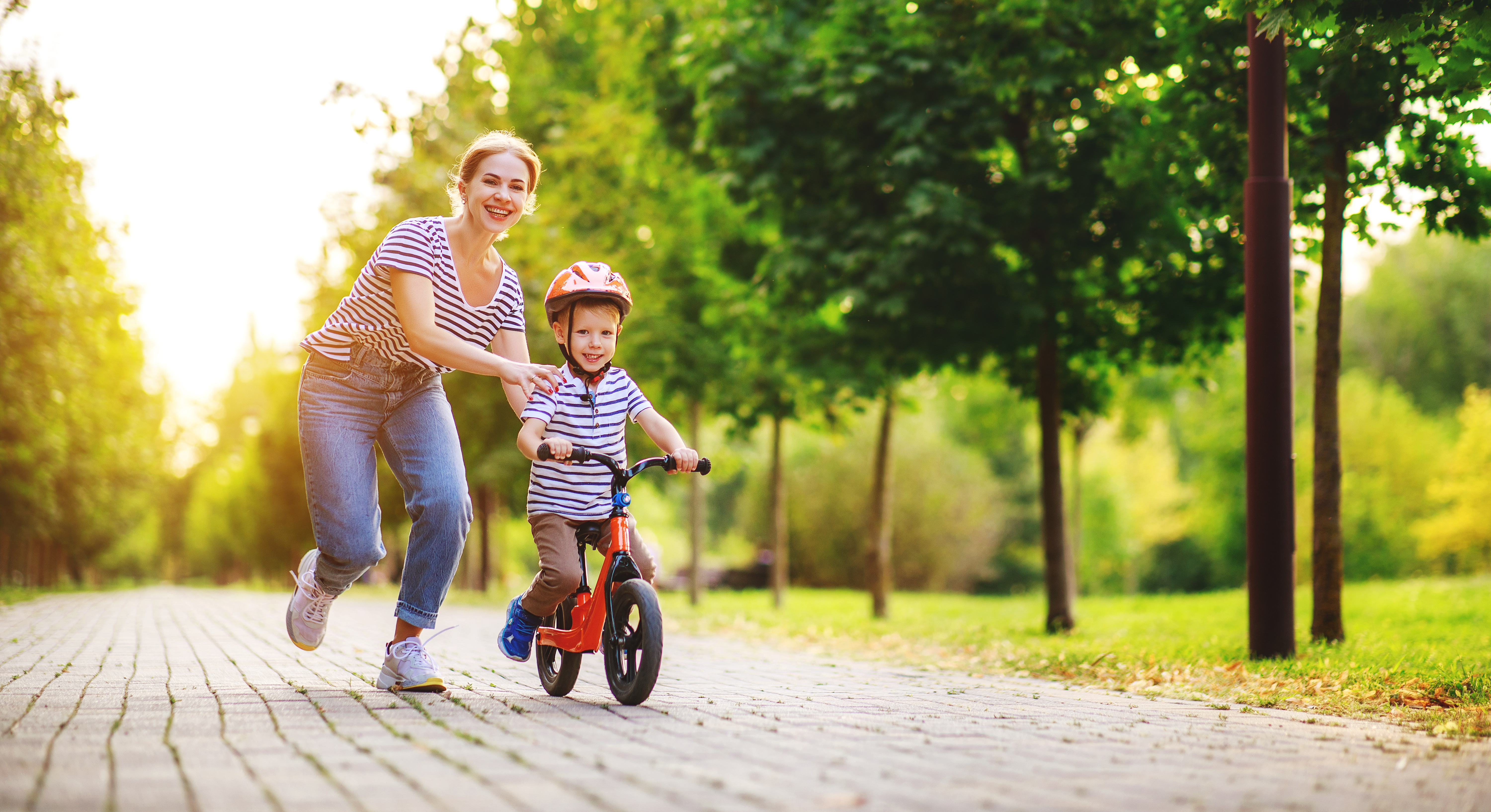 Parent and child enjoying a tree-lined park path