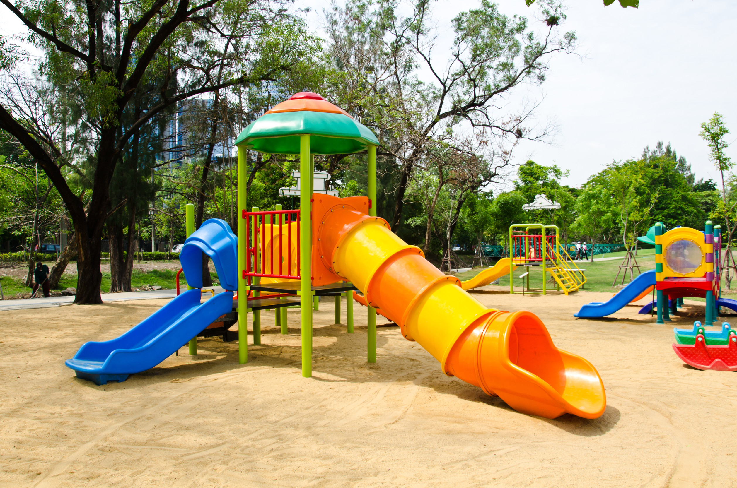 Colorful playground surrounded by mature trees
